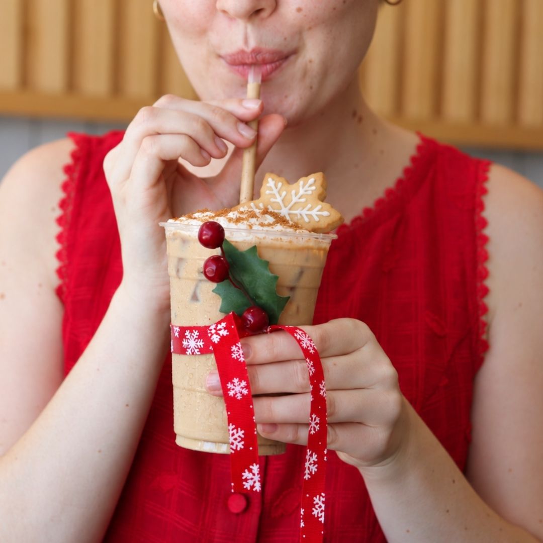 Lady sipping on an iced cookie butter latte made with Mocafe mix